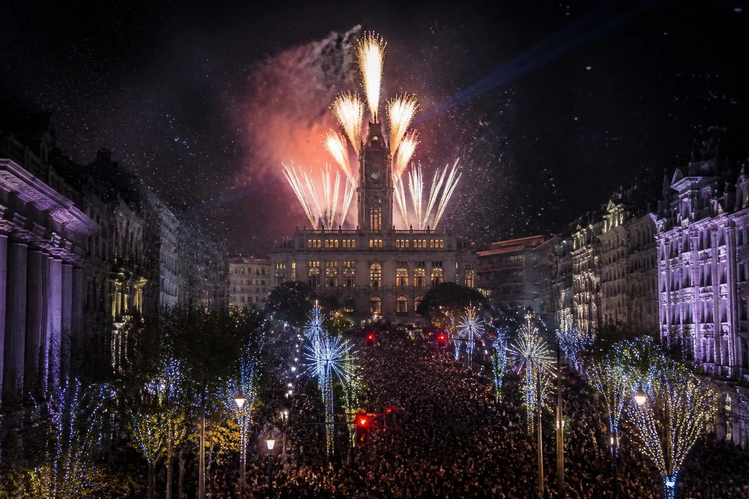 Foule sur l'Avenida dos Aliados à Porto et feu d'artifice tiré depuis l'hôtel de ville